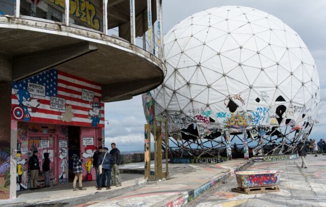 Rooftop with graffiti on the walls and a white sphere on the other side.