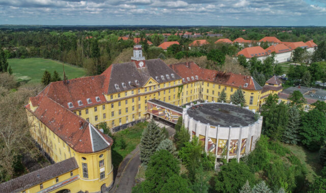 Aerial photo of Wünsdorf, a C-shaped building painted yellow.