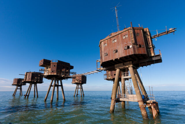 Five metal platform forts in the water.