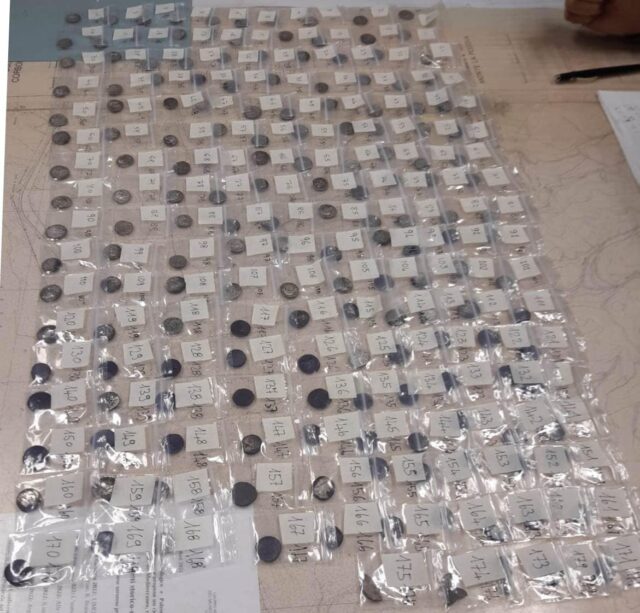 Silver coins individually bagged and laid out on the floor