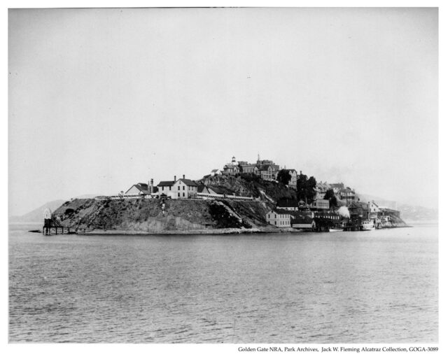 Distanced view of Alcatraz Island with small buildings on it. 