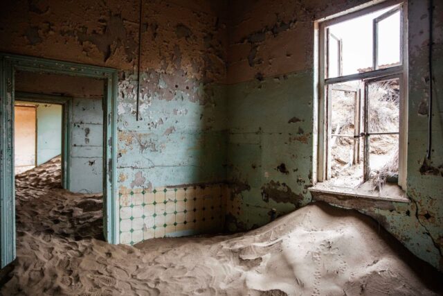 Interior of an abandoned house filled with sand.