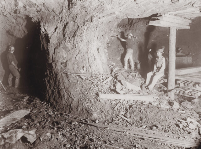 Men digging in an underground tunnel.