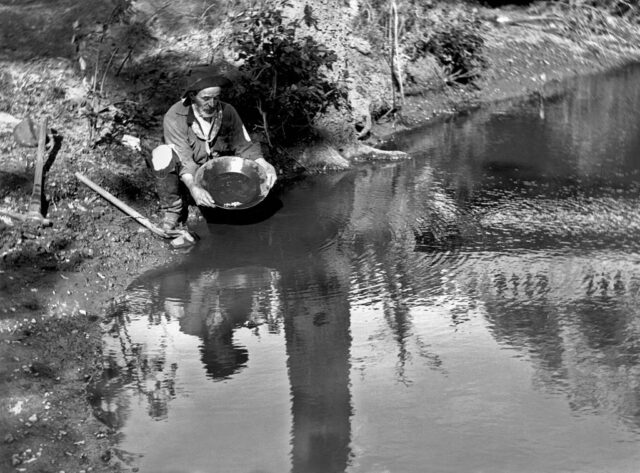 Prospector panning for gold along a river