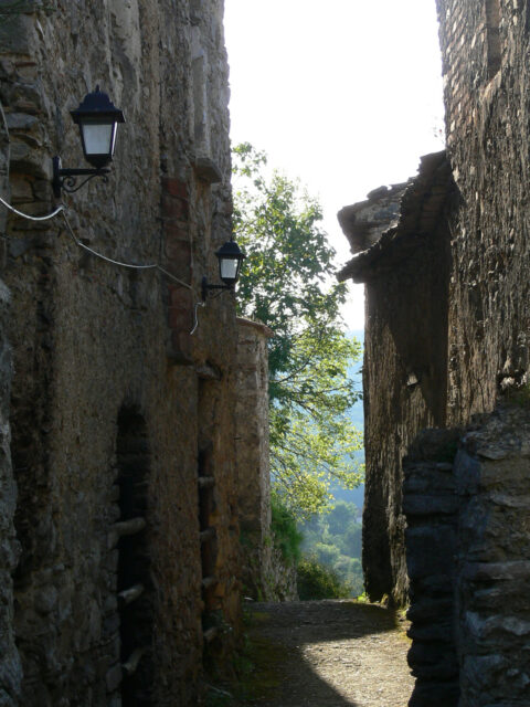 View of a narrow street within the abandoned village. Electric lights have been added as part of the preservation of the site.