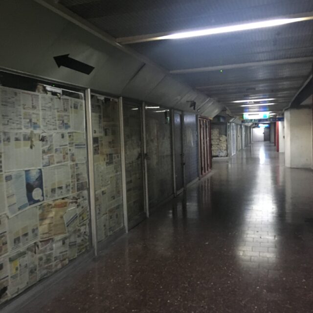 An empty hallway, newspapers on windows