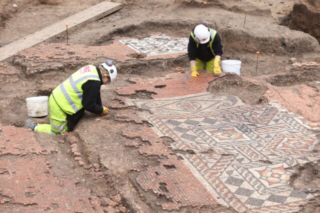 Two Museum of London Archaeology (MOLA) archaeologists excavating a mosaic at the Liberty of Southwark site