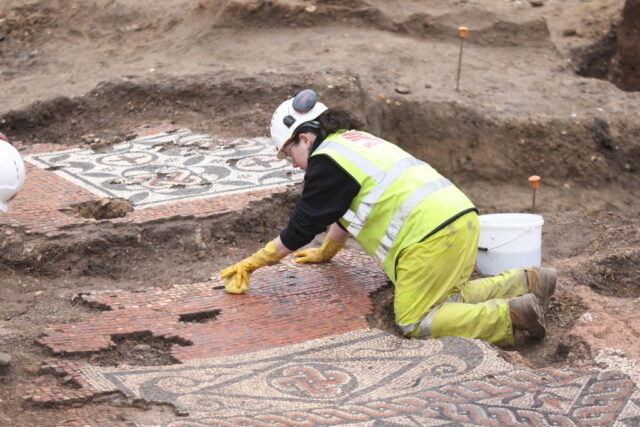 Museum of London Archaeology (MOLA) archaeologist excavating a mosaic at the Liberty of Southwark site