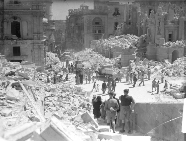 Townspeople standing around the ruins of a street in Valletta, Malta