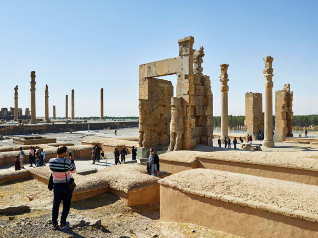 Tourists standing among the remains of the city of Persepolis