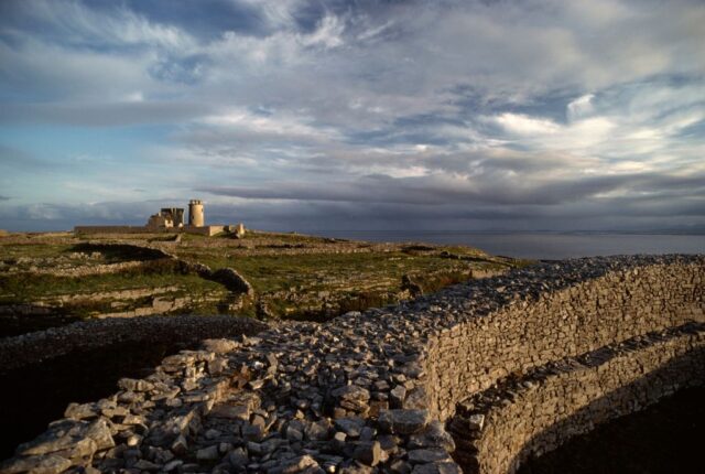 Lighthouse ruins near a stone seawall