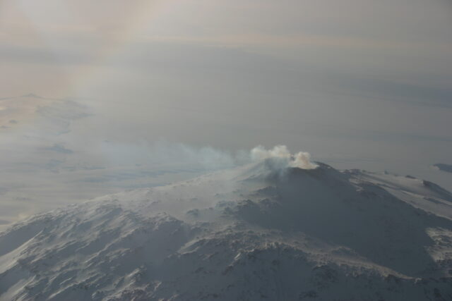 An aerial view of Mount Erebus, steam coming from its summit