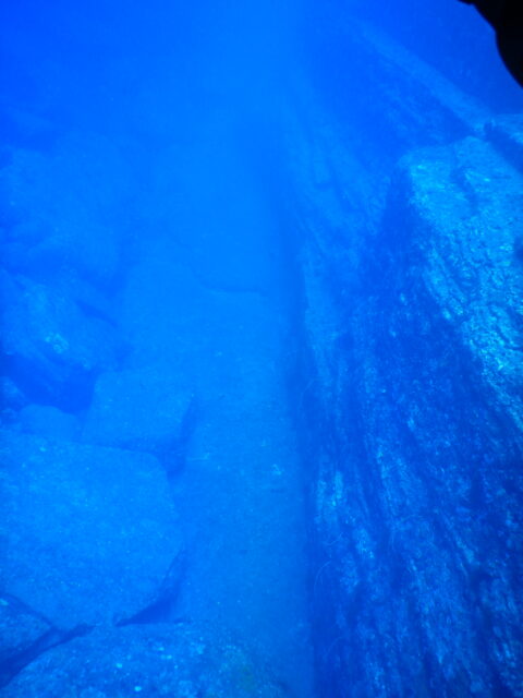 Underwater rocks line either side of a path.