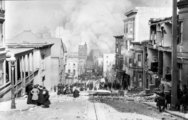 Looking Down Sacramento St., 1906. [verso:] "San Francisco: April 18, 1906." From As I Remember by local photographer Arnold Genthe: This photograph shows "the results of the earth quake, the beginning of the fire and the attitude of the people." It was taken the morning of the first day of the fire. Shows Sacramento St. at Miles Place (now Miller Place) near Powell St.