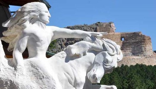 A small sculpture of the Crazy Horse Memorial in front of the real thing.