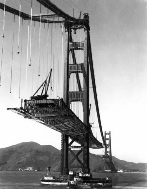 The road of the Golden Gate Bridge suspended before being placed during its construction.