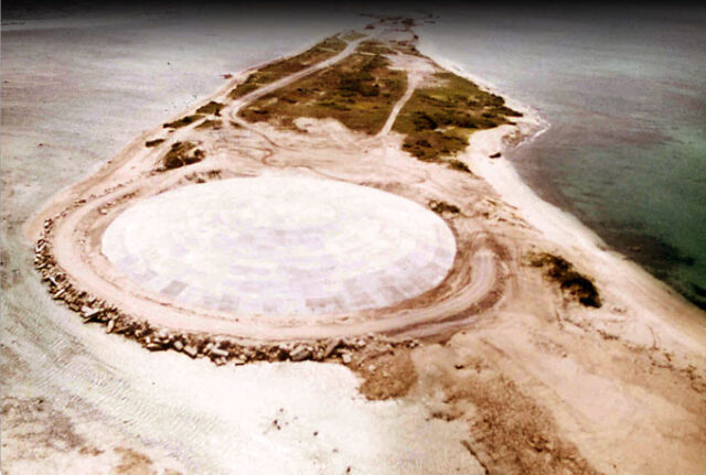 Aerial view of a concrete dome on an island.