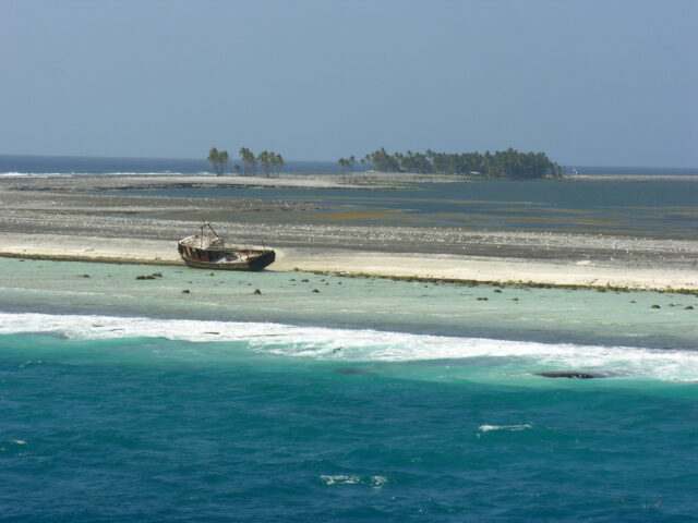 An abandoned boat on a shoreline.