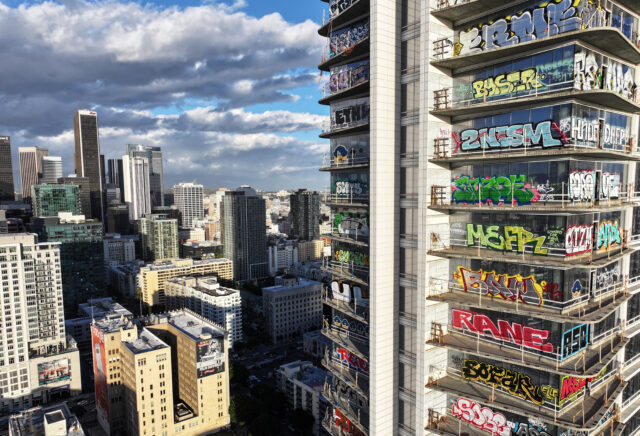 A view of building in LA, a skyscraper with graffiti on its windows. 