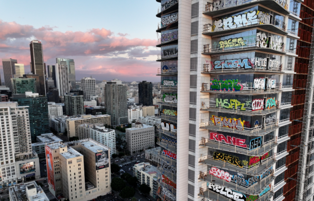 A view of building in LA, a skyscraper with graffiti on its windows.