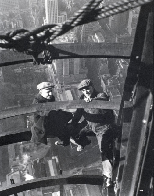 Two construction working sitting on a skyscraper's steel frame.