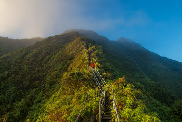 A woman walking steps on a Hawaiian mountaintop.