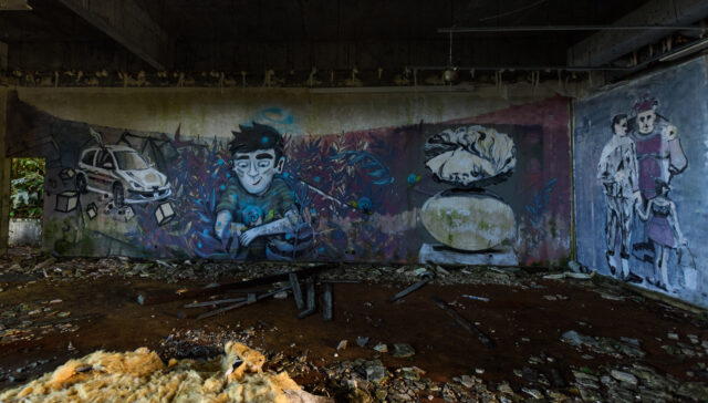 Graffiti on a wall in an abandoned concrete hotel.
