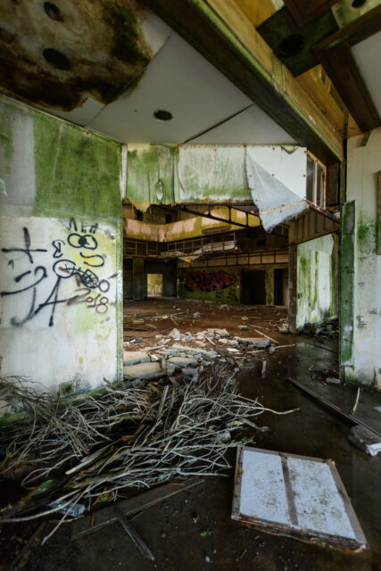A destroyed and abandoned room looking out into a courtyard.