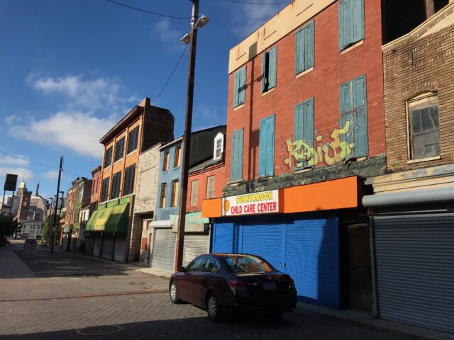 A row of abandoned buildings on a street.