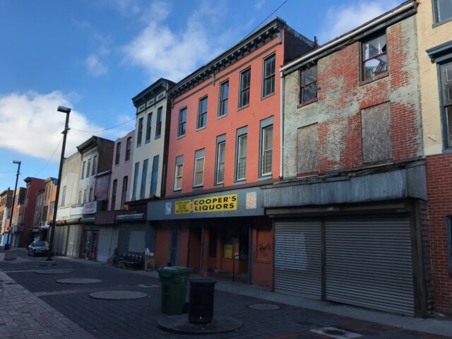 A row of abandoned buildings on a street.