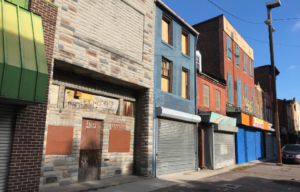 A strip of abandoned buildings on a road.